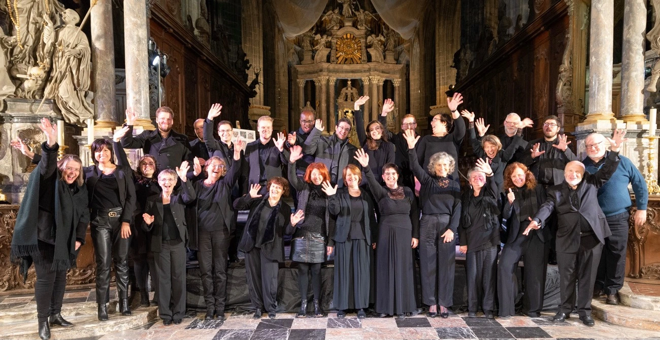 The vocal ensemble Appassionato is in a cathedral and signals to the camera