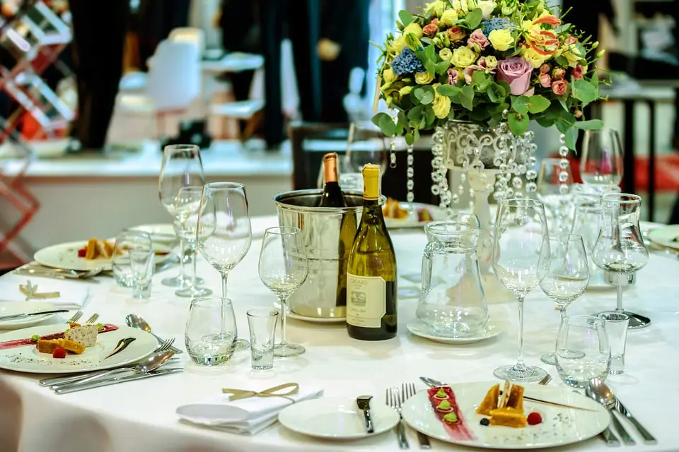 A well decorated and covered table at a banquet