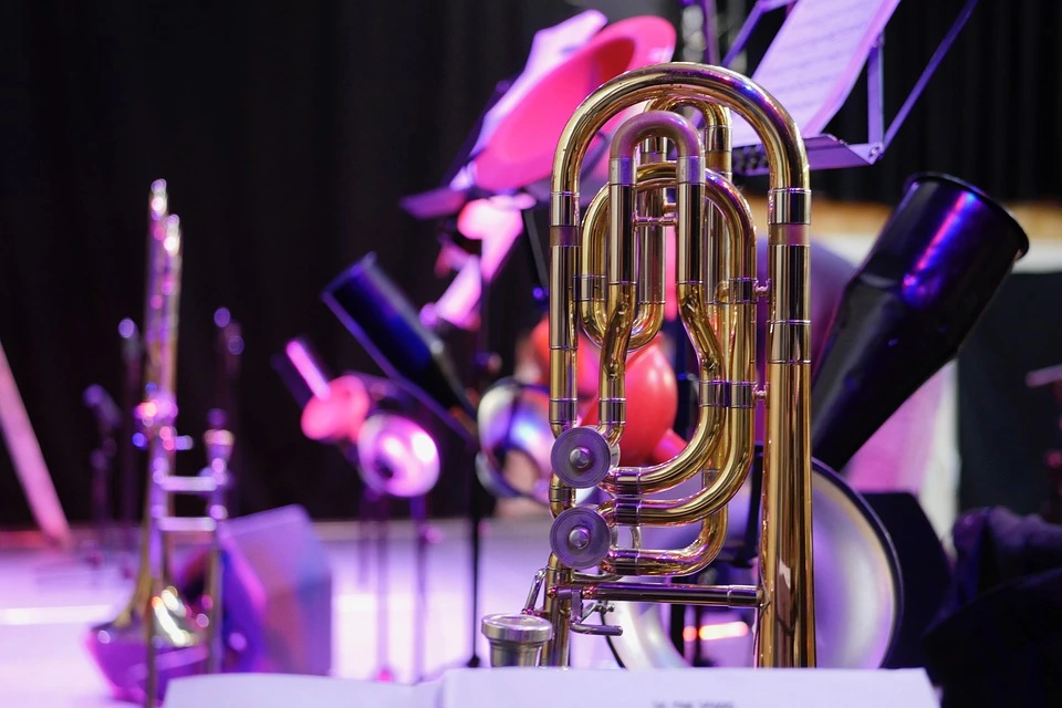 A trombone in close-up standing on the stage with many colored lights